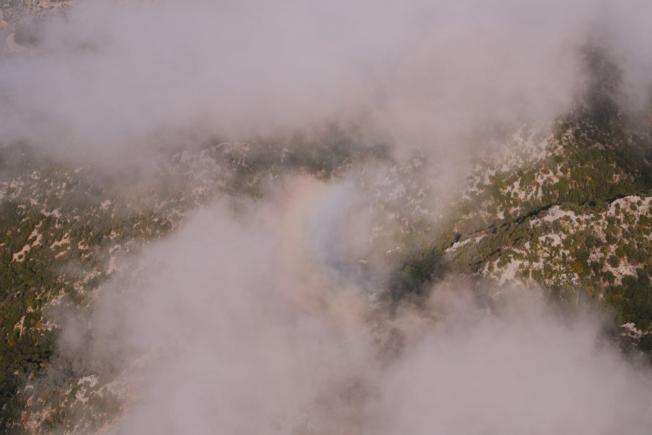 Rocky mountainside appearing through a gap in the cloud