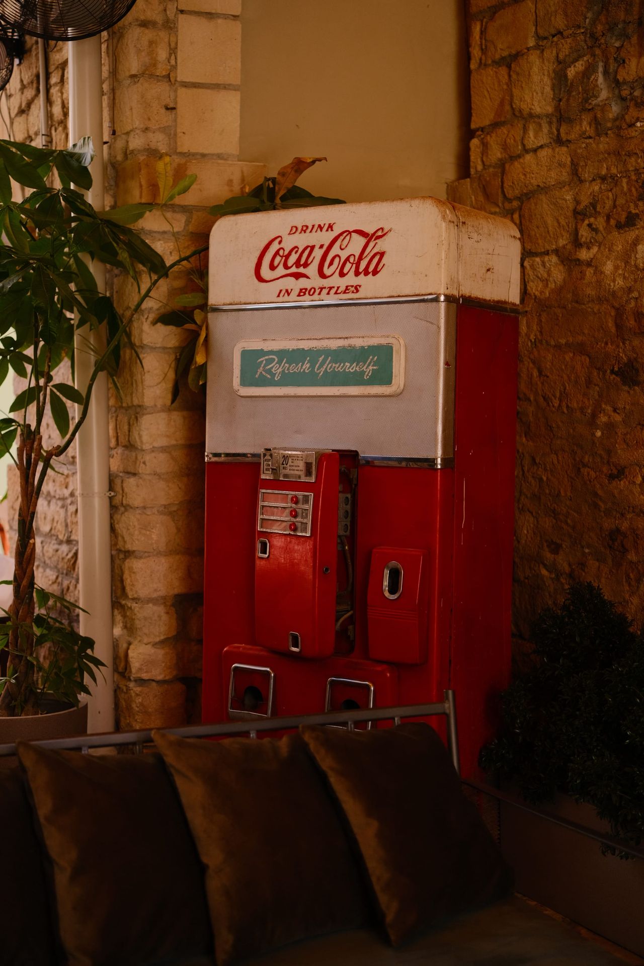 Vintage red Coca-Cola vending machine in a stone-walled corner, Cyprus