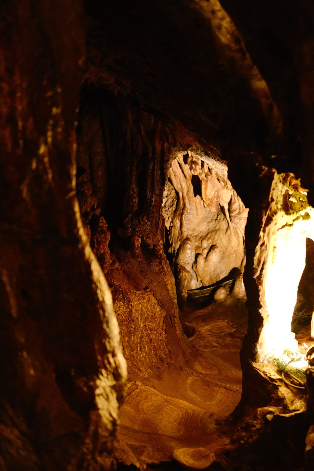 Narrow limestone passage lit with warm amber light