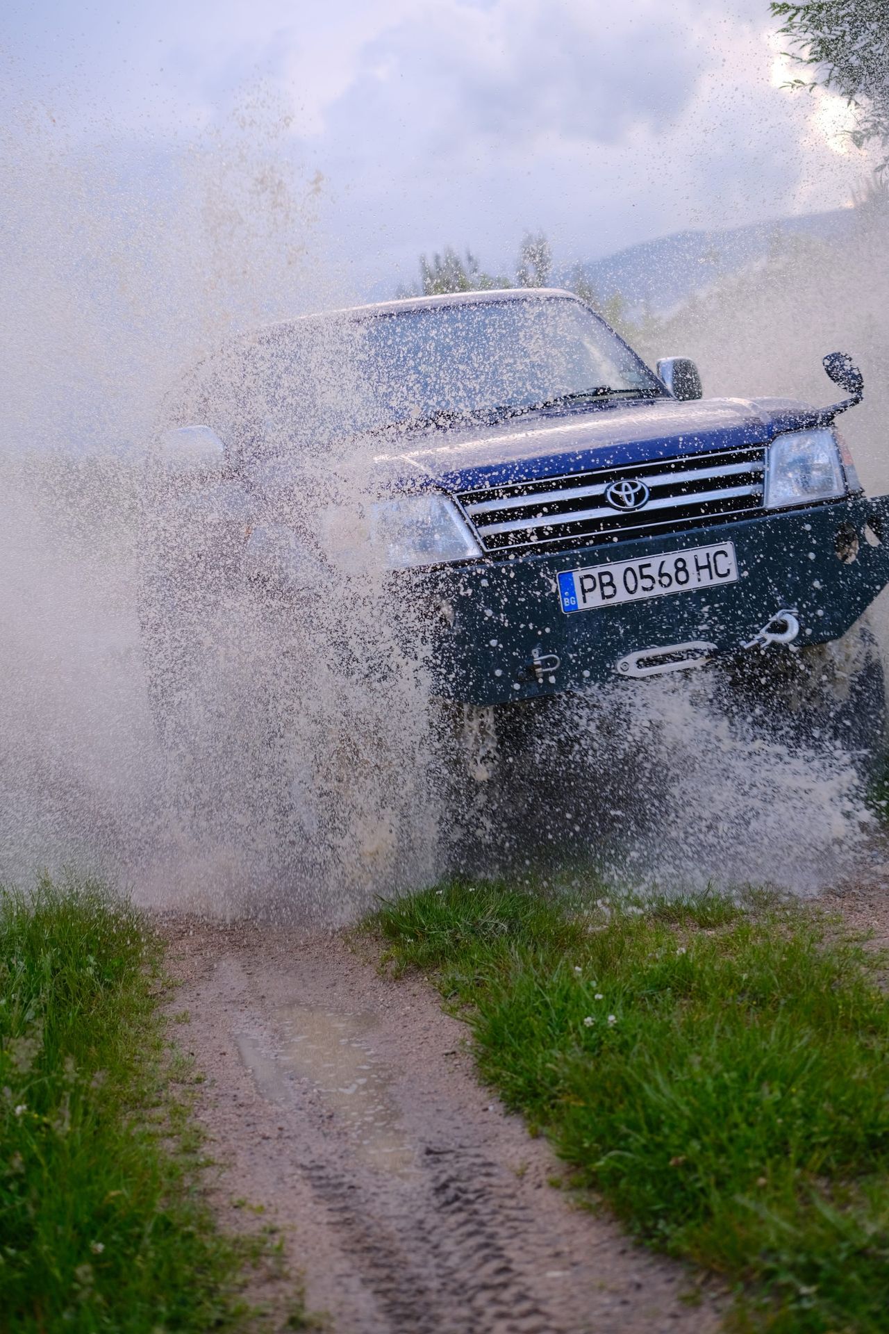 Four-wheel-drive vehicle cutting through the puddle at speed
