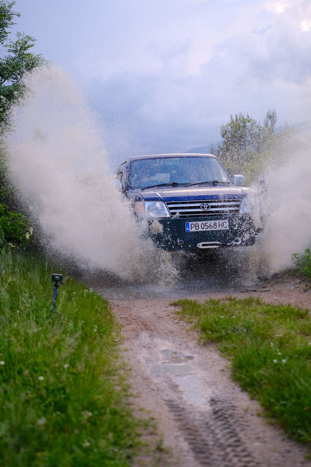 Water spraying around the vehicle on the muddy track