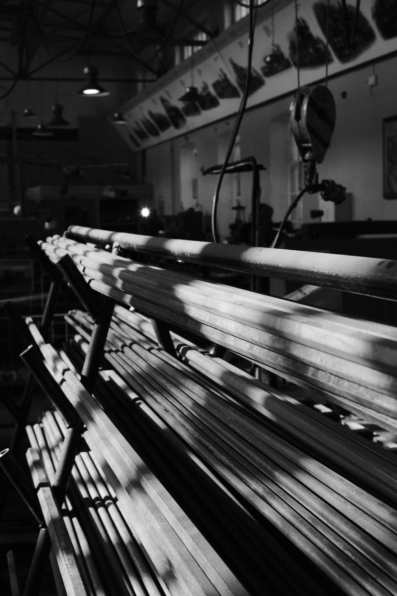 Monochrome workshop machine with parallel shafts receding into shadow.