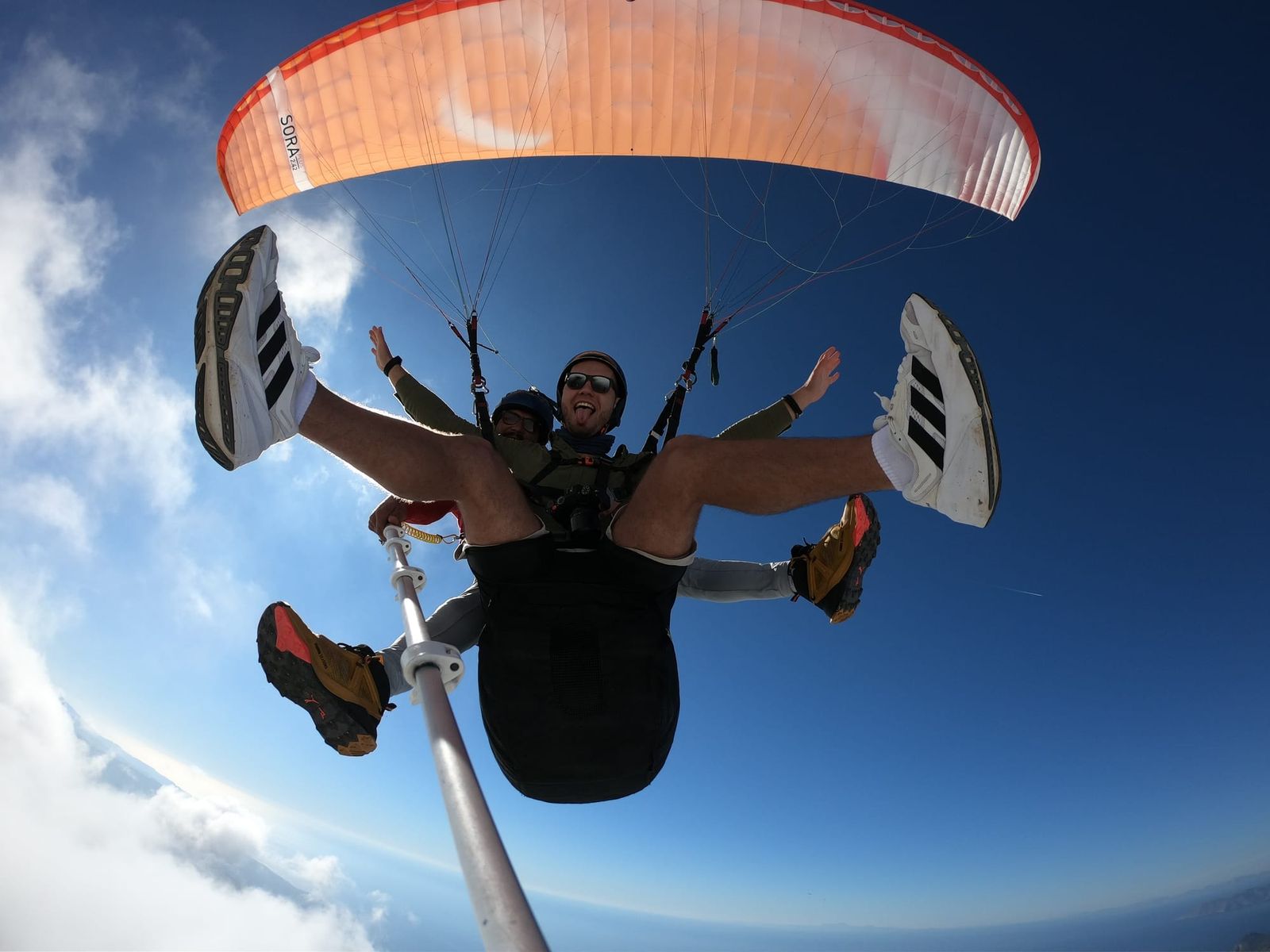 Upward action-camera view of the tandem pair and orange canopy