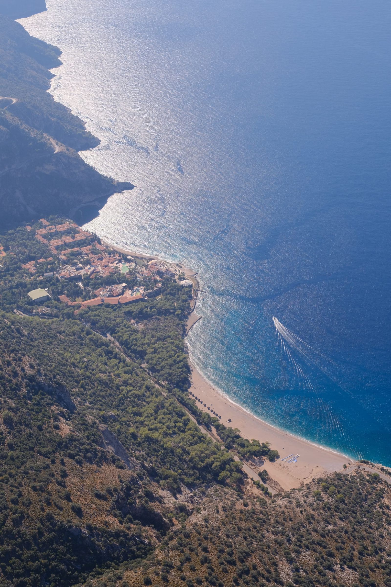 Long sandy beach and bright sea seen during the paragliding flight