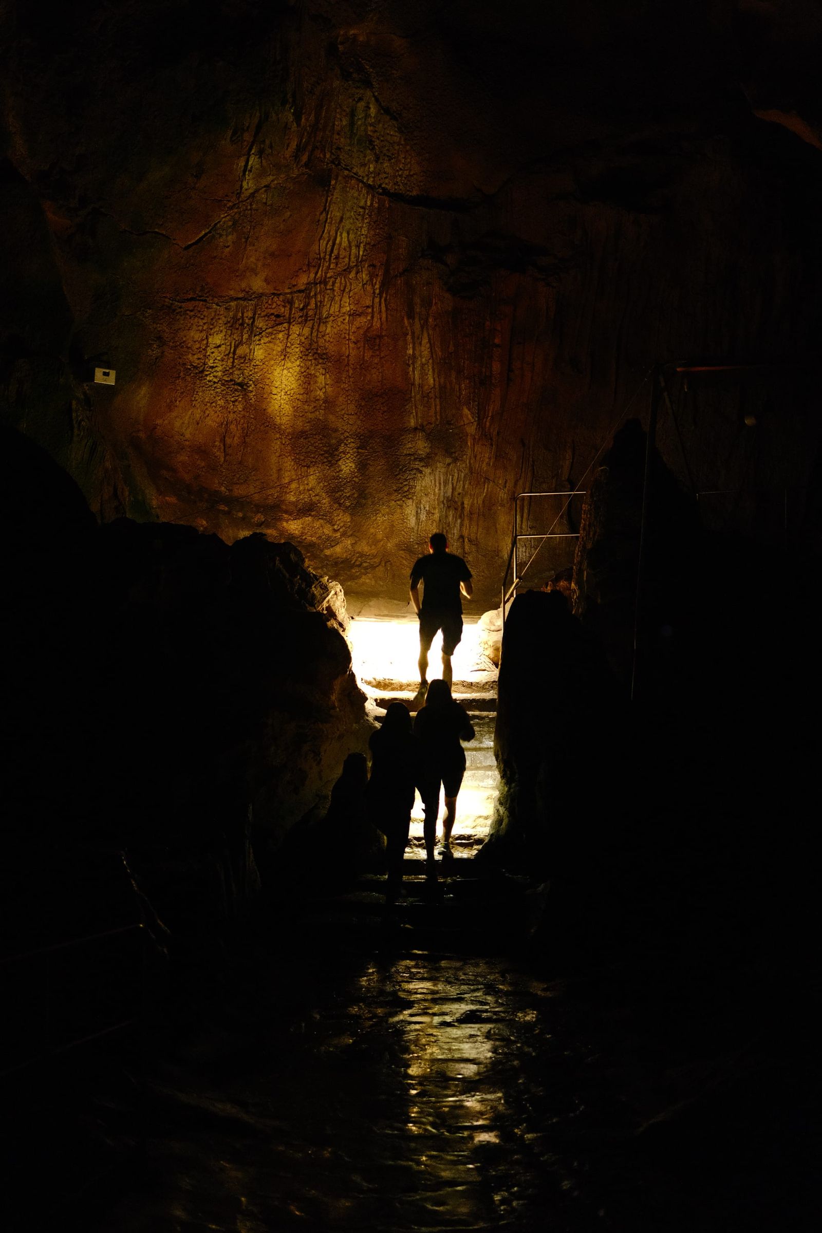 Silhouetted visitor standing in a dark chamber of Ledenika Cave