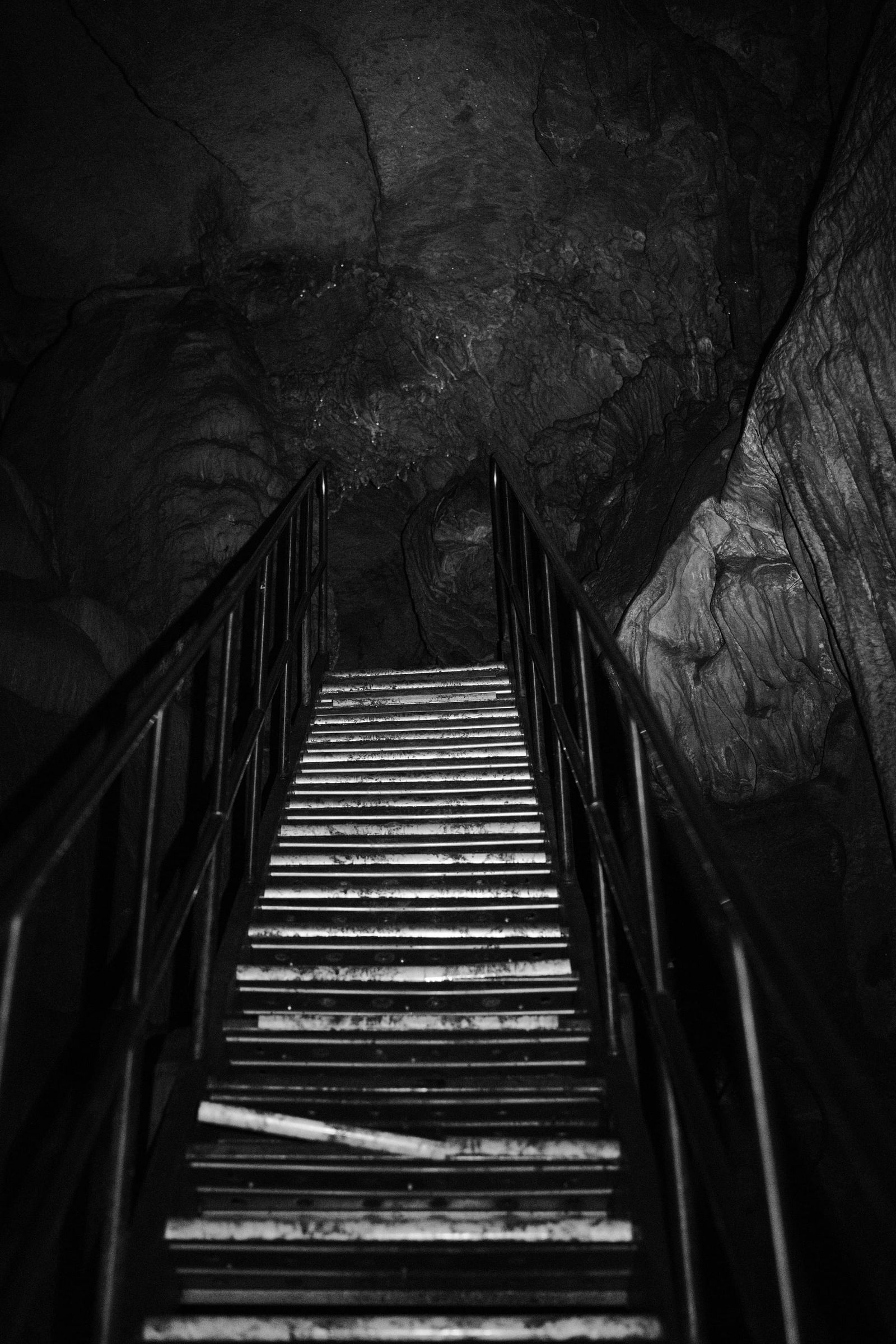 Steep staircase disappearing into a dark cave passage
