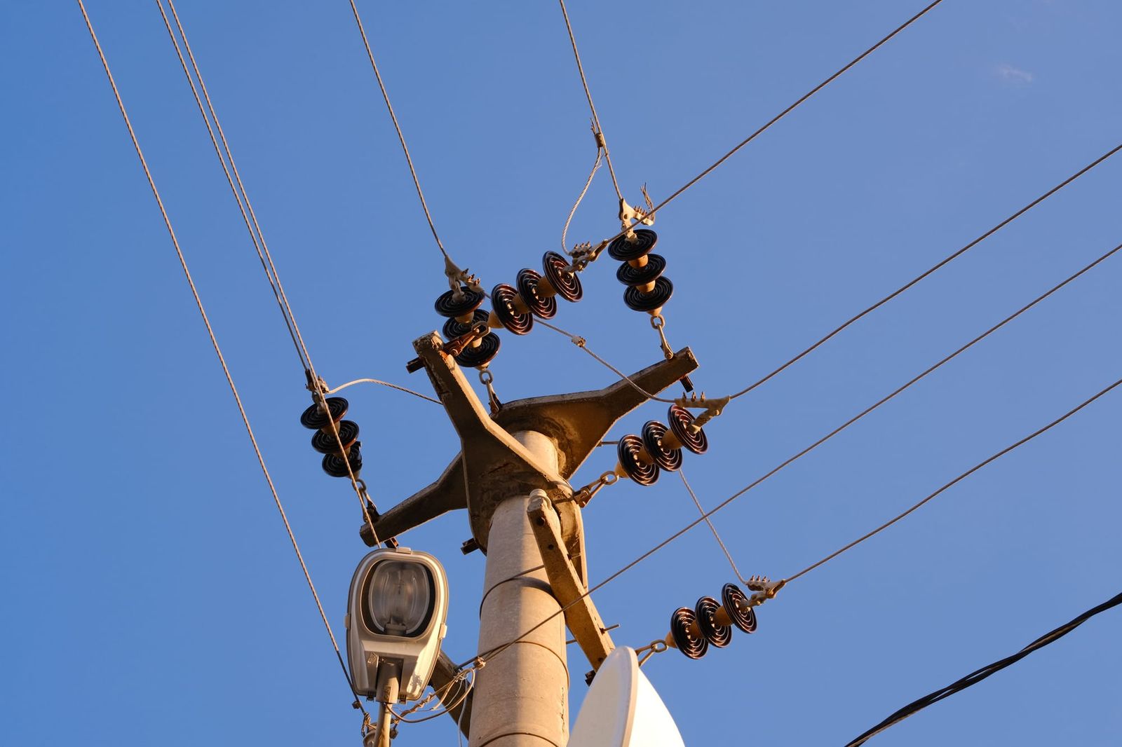 Power pole and overhead lines against a clear blue sky