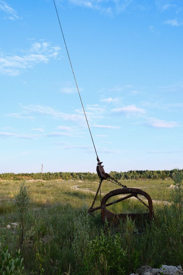 Weathered bicycle standing in a grassy field beneath a bright blue sky