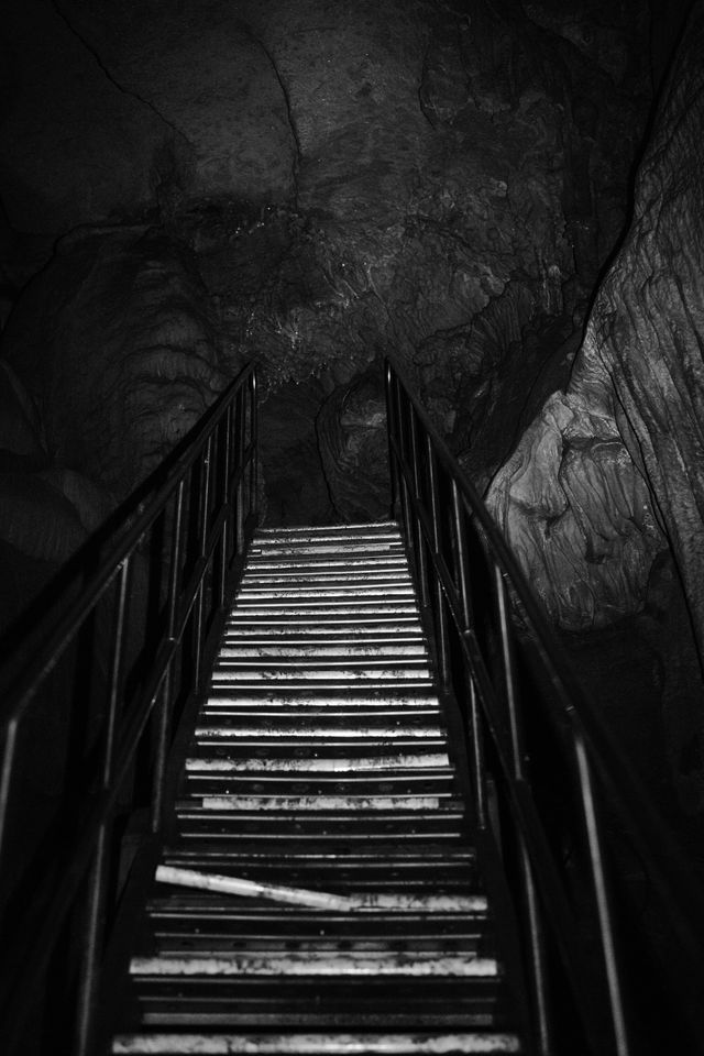 Steep staircase disappearing into a dark cave passage