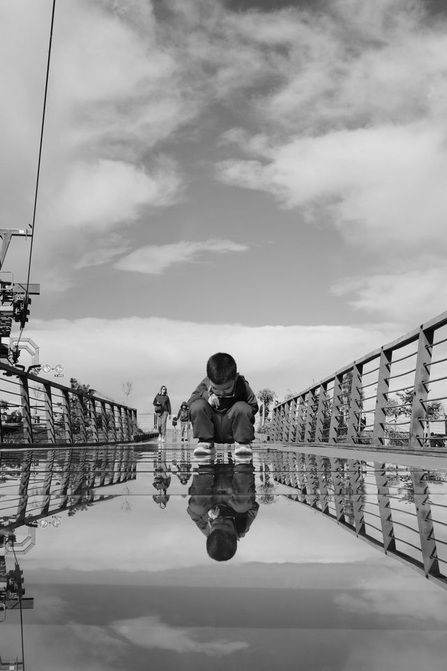 Person reflected in the glass floor of a mountain viewing platform