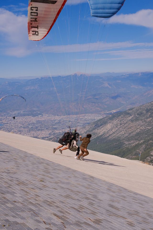 Tandem paraglider running from a sloped launch ramp on Babadağ
