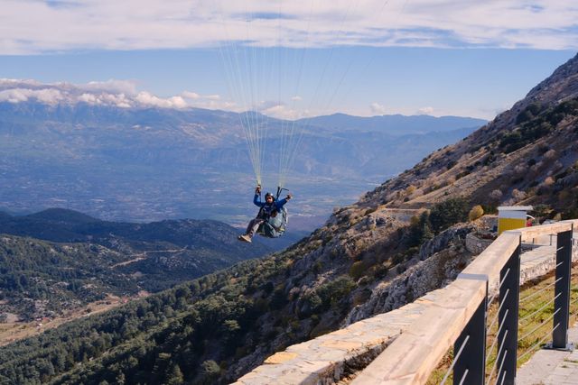 Tandem paraglider airborne beside Babadağ with mountains behind