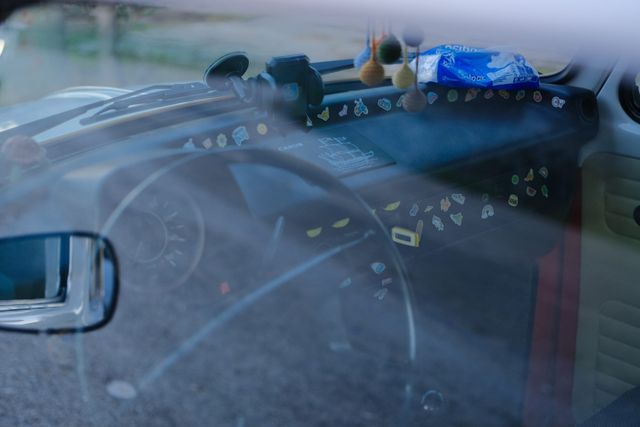 Toy vehicles lined across the dashboard behind a car windscreen
