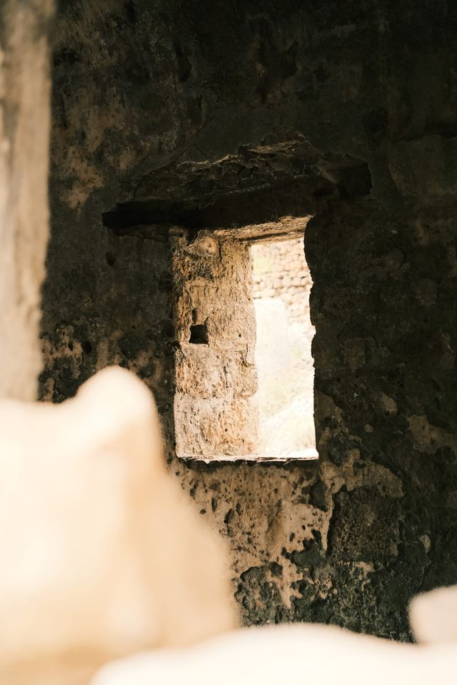Sunlit window opening inside a ruined stone building