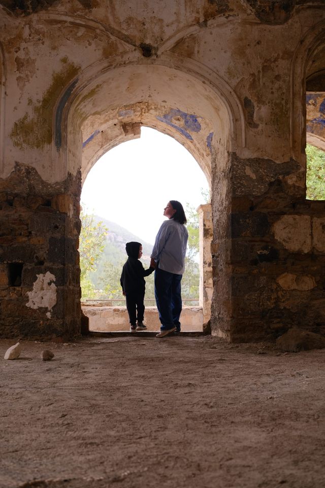 Adult and child silhouetted in the doorway of a Kayaköy ruin