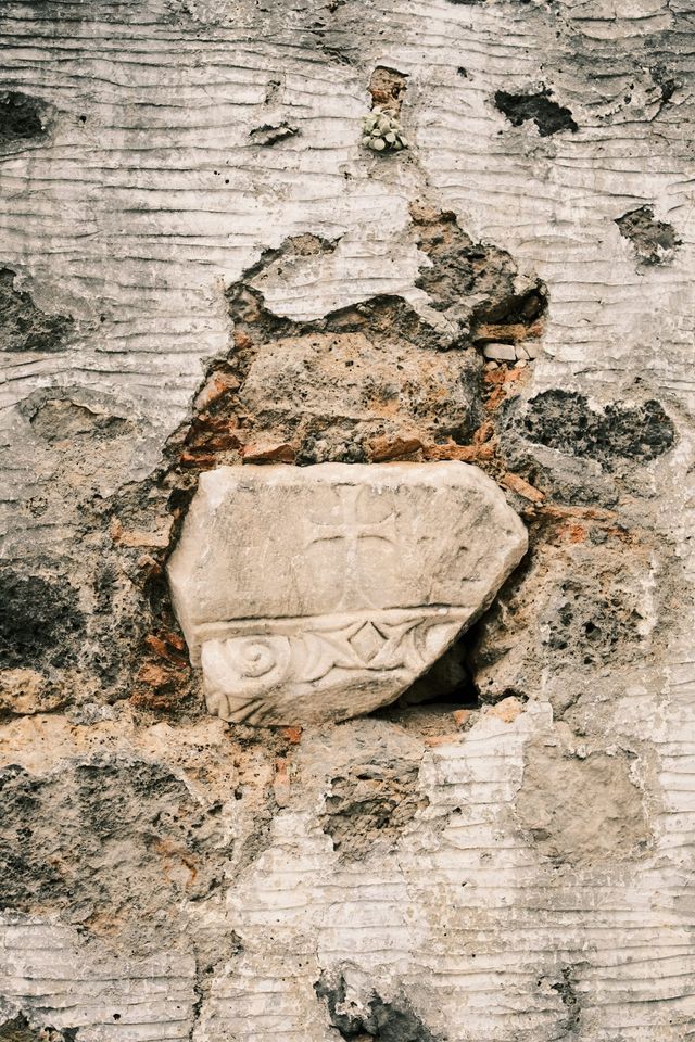 Carved stone basin embedded in a weathered wall