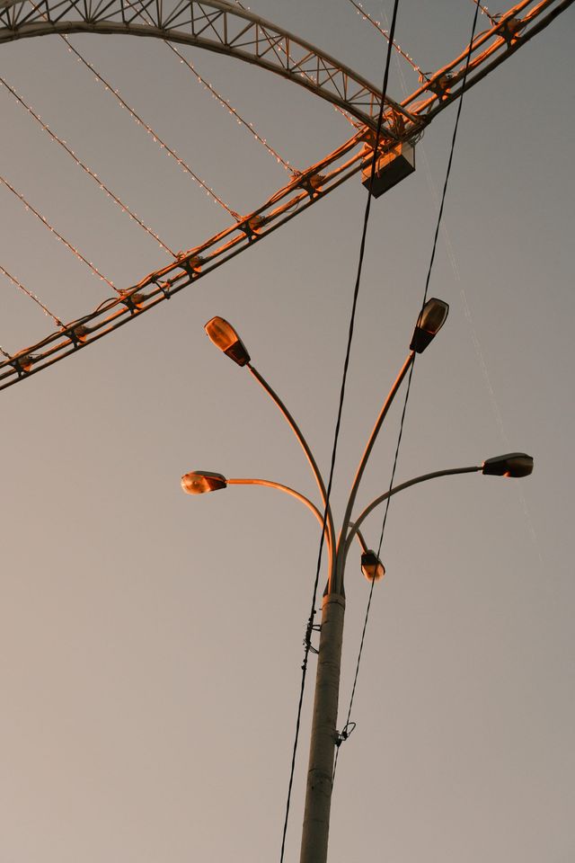 架空の電線網の下に扇状の街灯と暖かな明かりが見える。